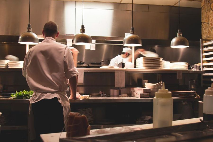 Des cuisiniers au travail en cuisine, de dos